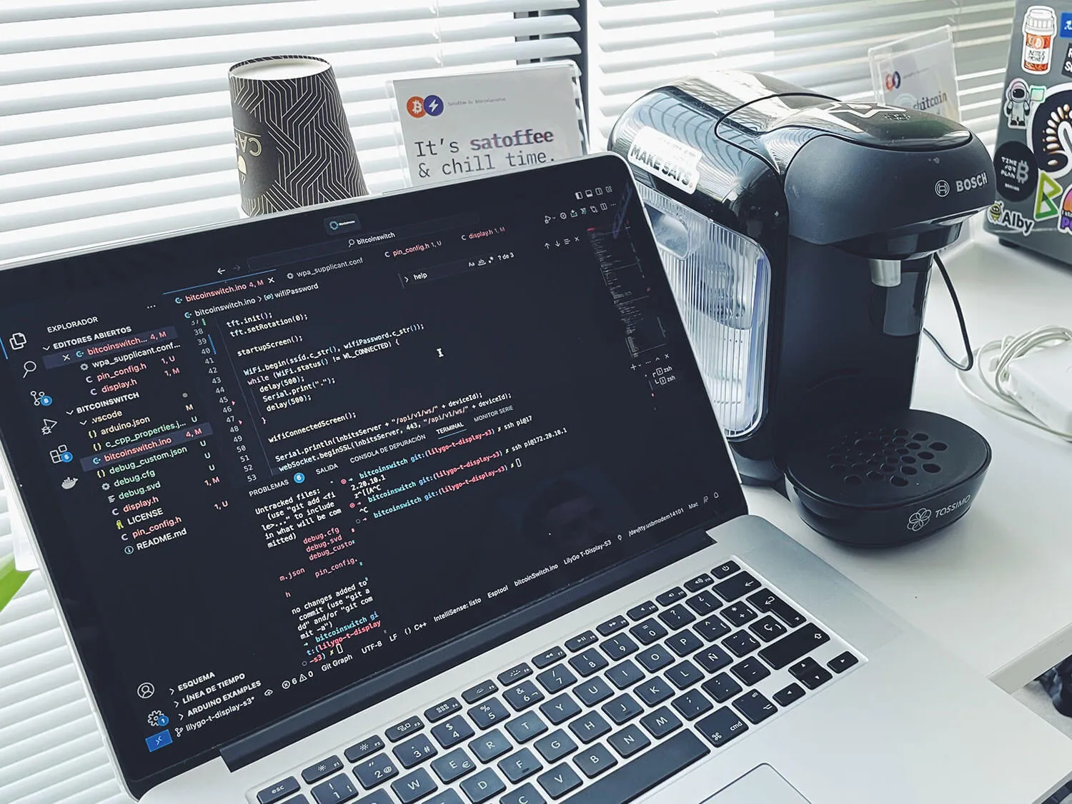Portátil con el código de Satoffee junto a la cafetera