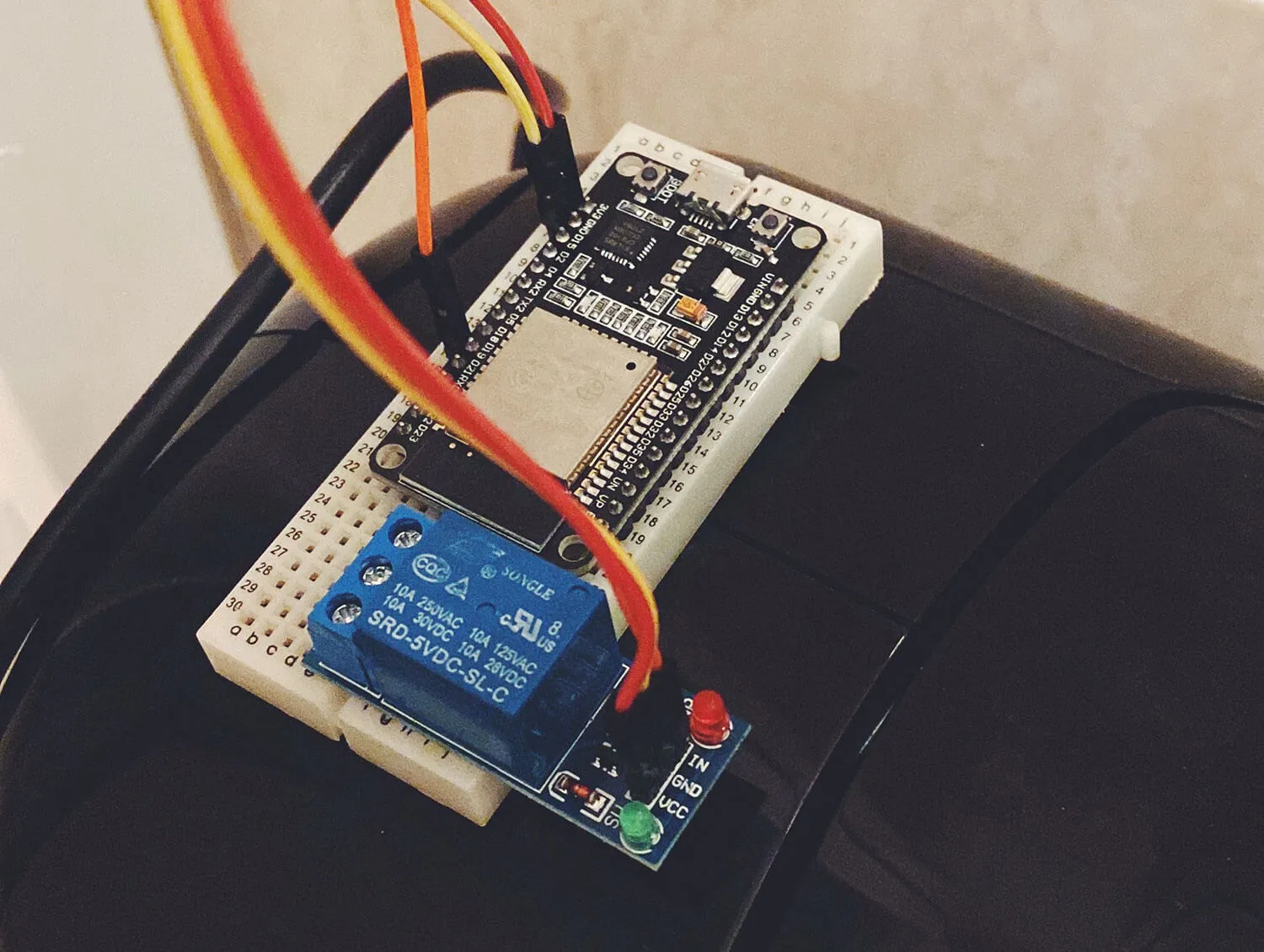 ESP32 y relé sobre una protoboard encima de una cafetera